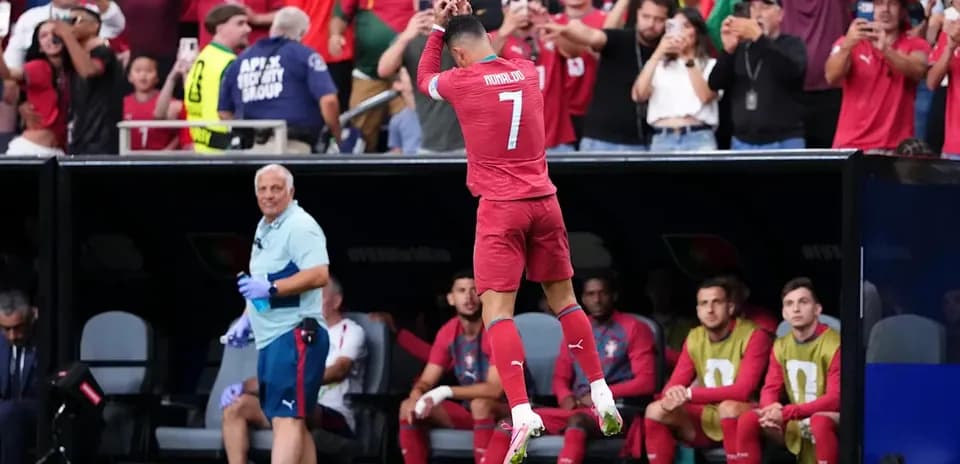 Futbolchi maydonga kirishdan oldin sakrab turibdi