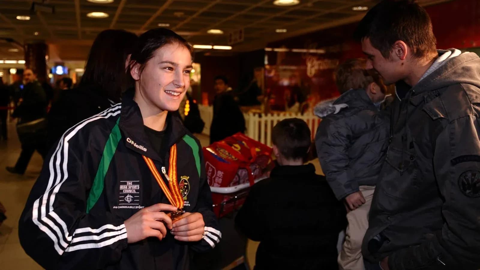 Athlete holding medal at an airport event
