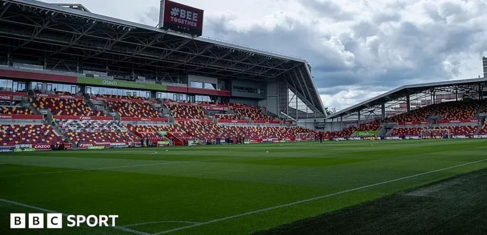 Stadium interior with empty seats and green pitch