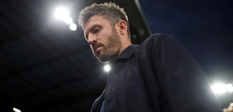 Football manager walking on the pitch at night