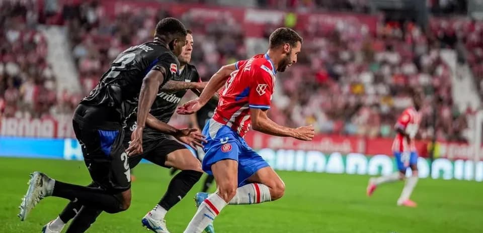 Futbolchi to'pni ushlashga harakat qilmoqda