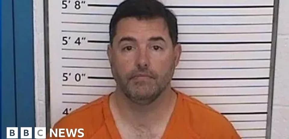 Mugshot of man in orange jumpsuit against height chart