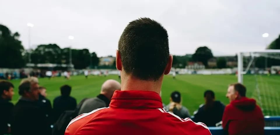 Fan watching football match from the sidelines