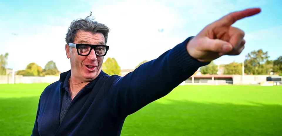 Man gesturing on a green football field