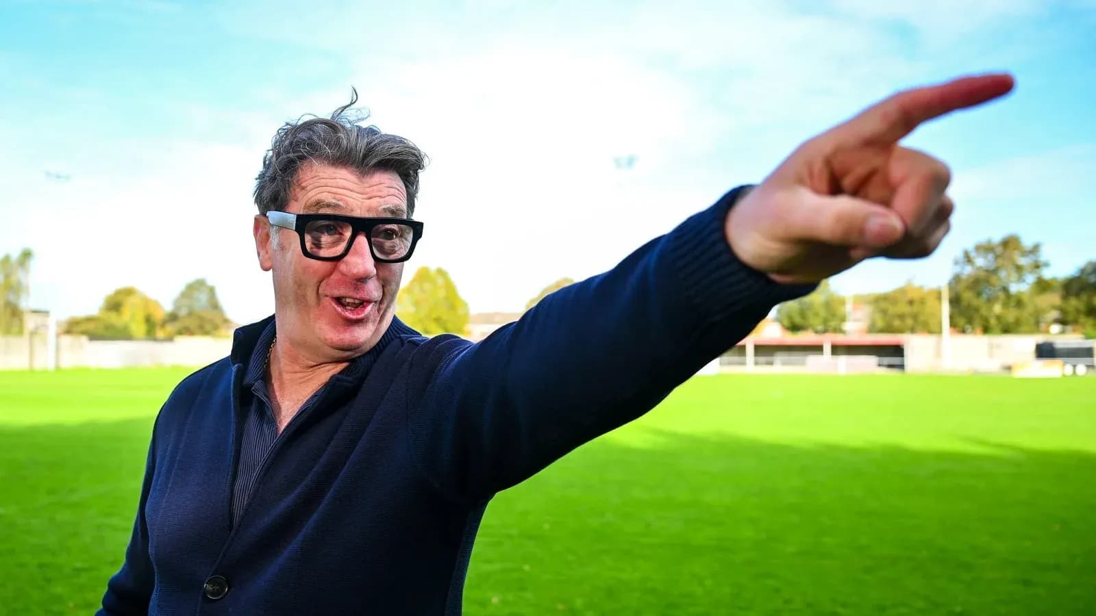 Man gesturing on a green football field