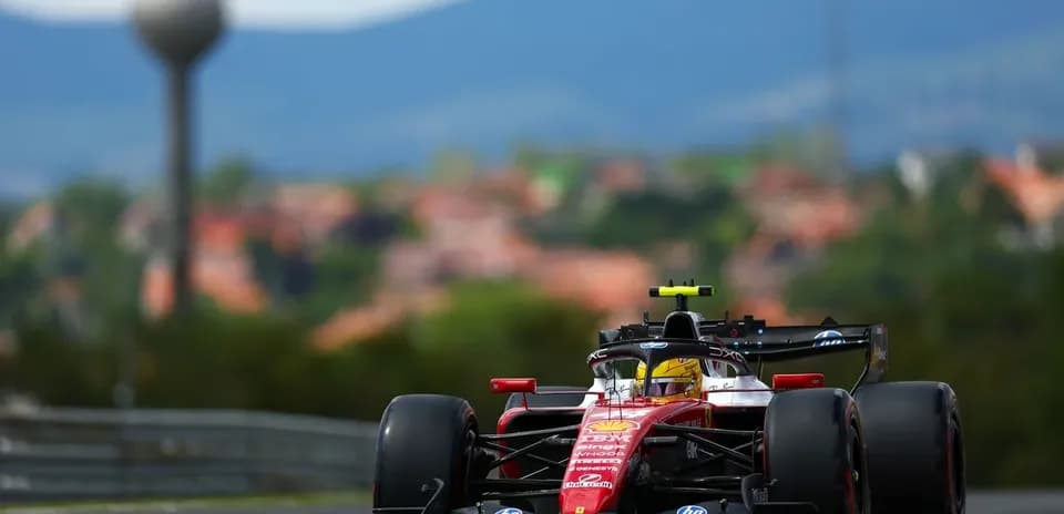 Formula 1 car racing on track with hills background