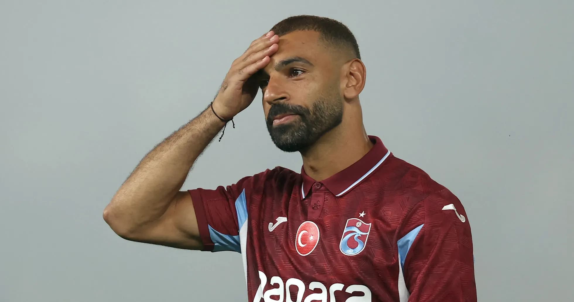 Futbolchi boshiga qo'l qo'yib turibdi