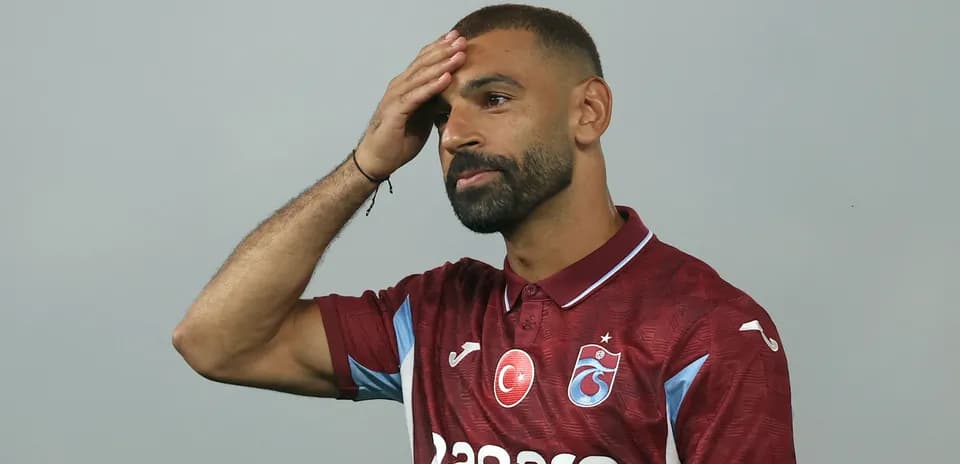 Futbolchi boshiga qo'l qo'yib turibdi