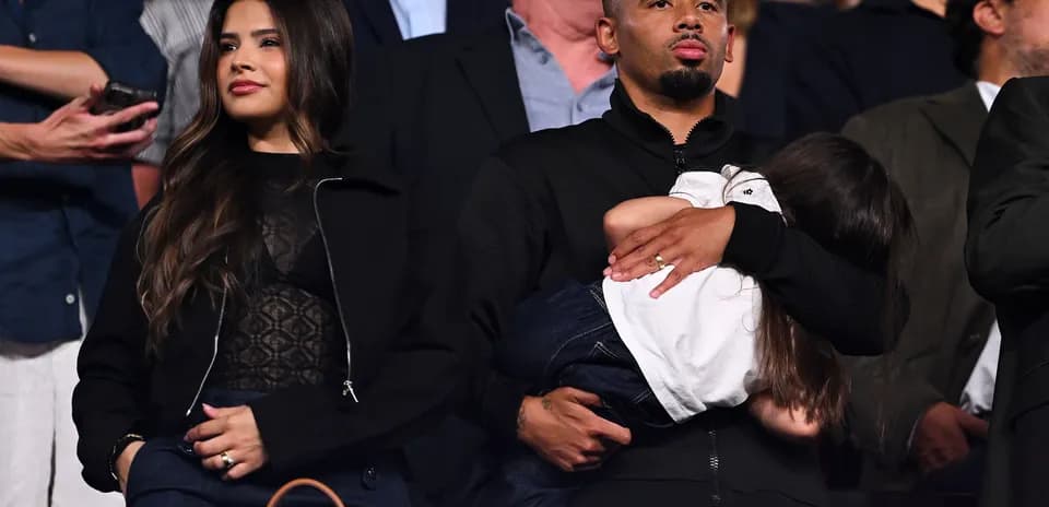 Couple watching event, man holding child