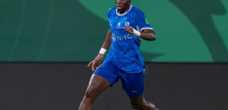 Futbolchi to'pni ushlagan holda yugurmoqda