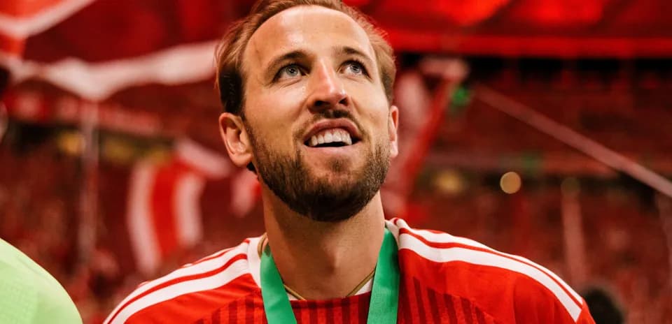 Futbolchi medal bilan maydonda g'alaba nishonlayapti