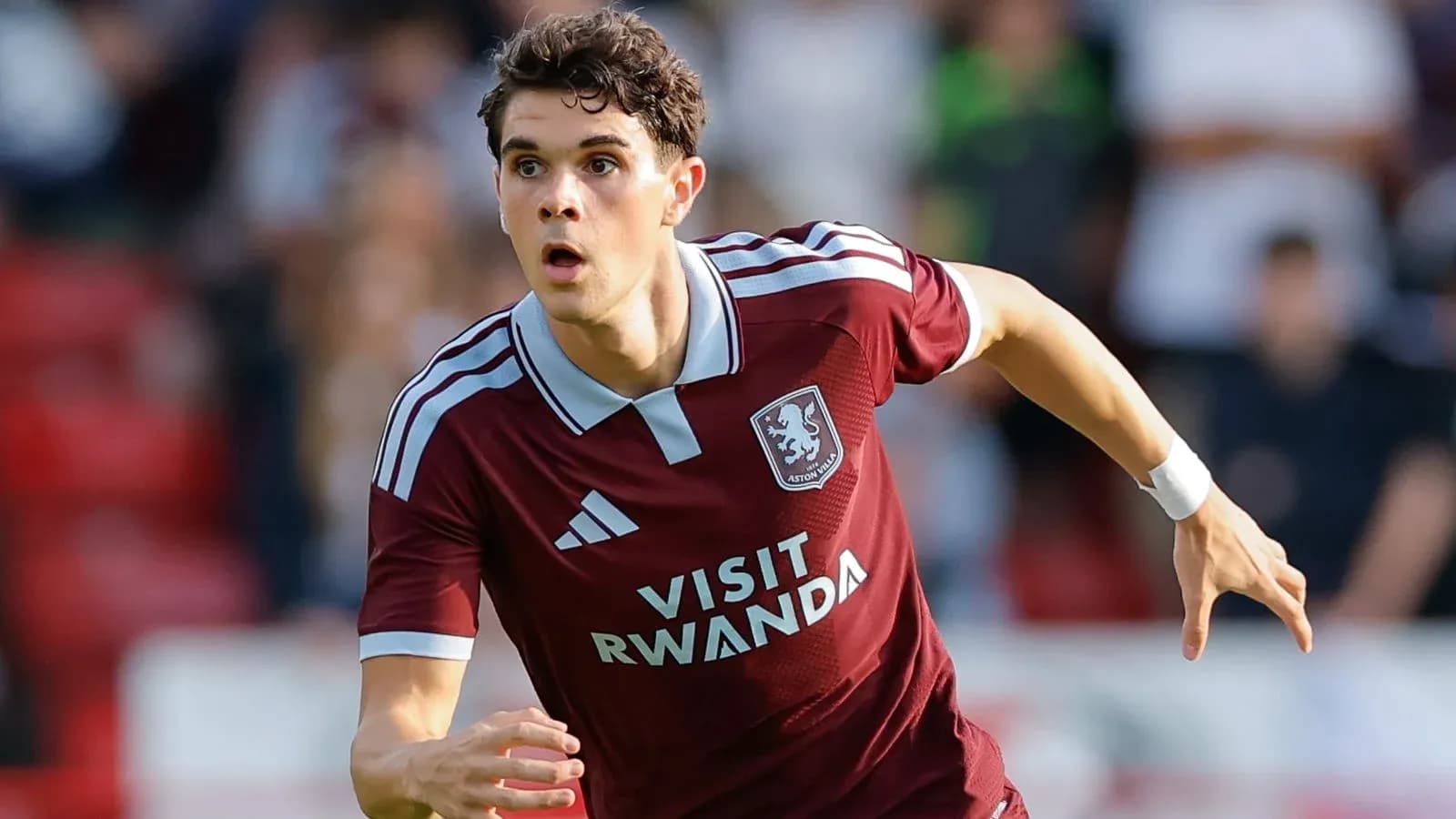 Futbolchi Aston Villa formasida maydonda harakatlanmoqda