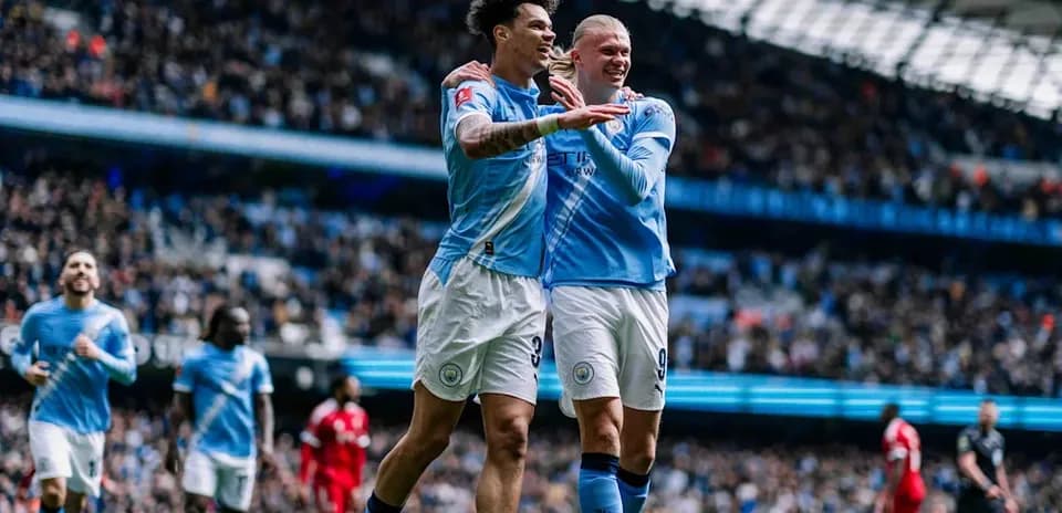 Manchester City players celebrating a goal on pitch