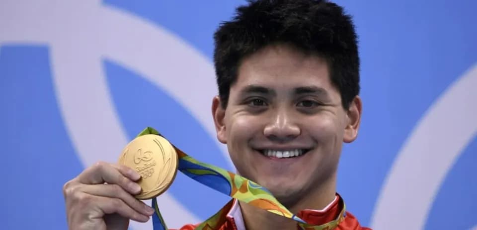 Sportchi oltin medalni ko'tarib turibdi