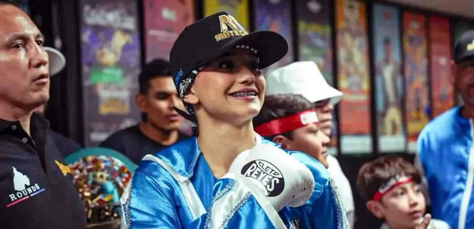 Boxer in blue robe smiling before match