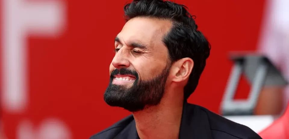 Man smiling with a red background behind him