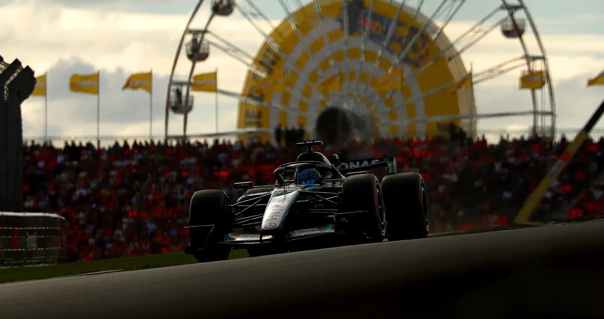 Formula 1 car racing with Ferris wheel in background