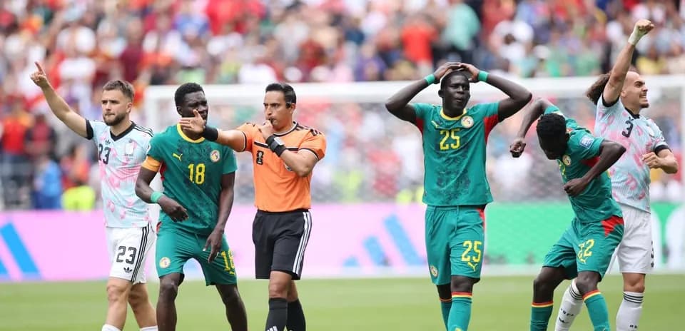 Referee signaling during Senegal match with players
