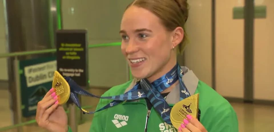 Sportchi oltin medal bilan aeroportda tabassum qilmoqda