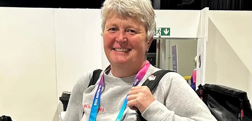 Woman smiling with a medal at an event
