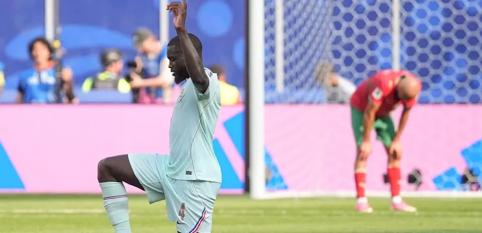 Defender kneeling on pitch during football match