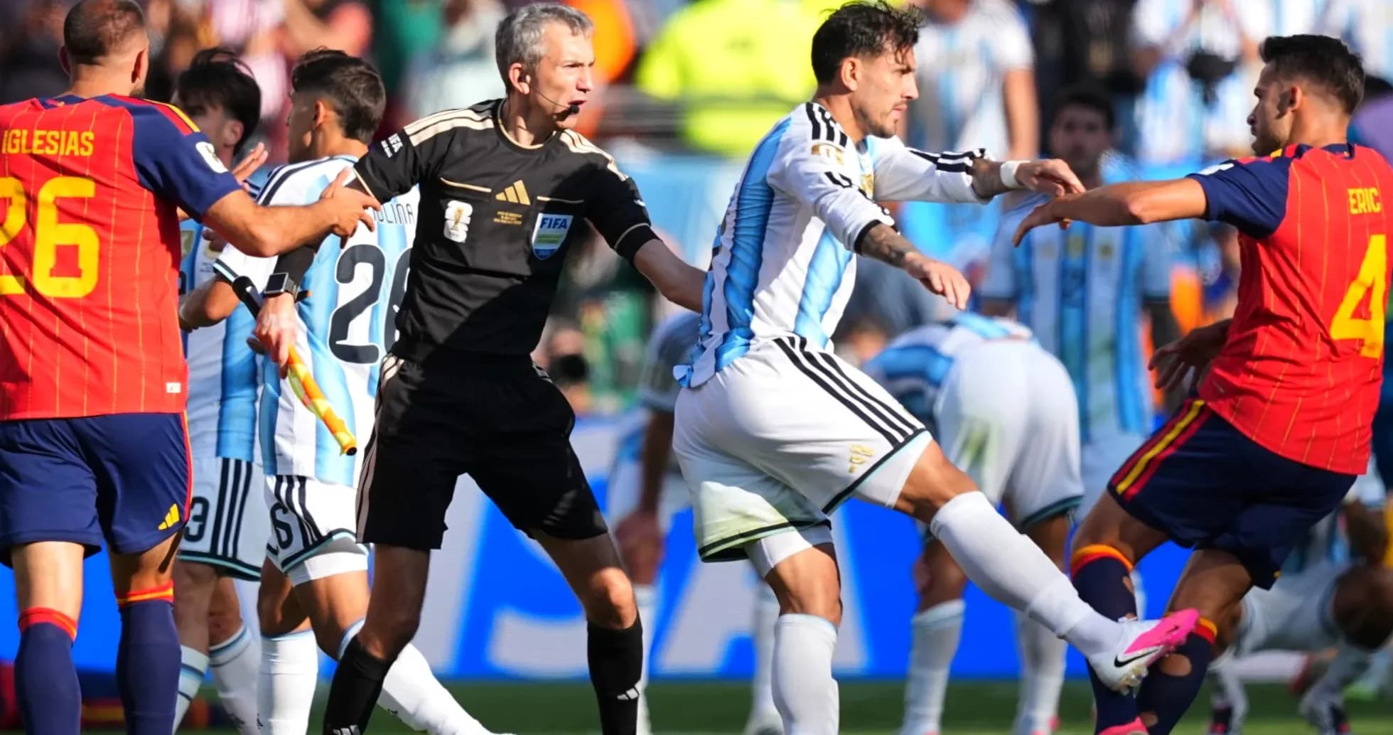 Players clashing during match with referee intervening