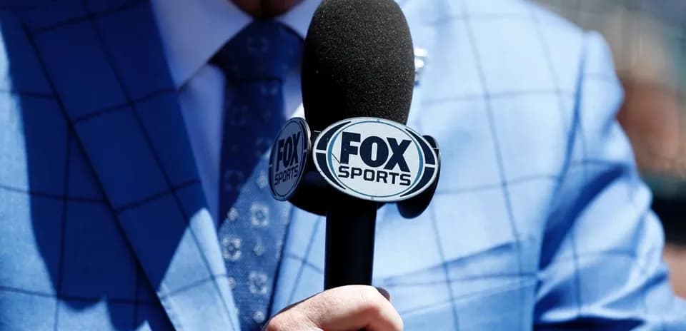 Mic with FOX Sports logo held by presenter