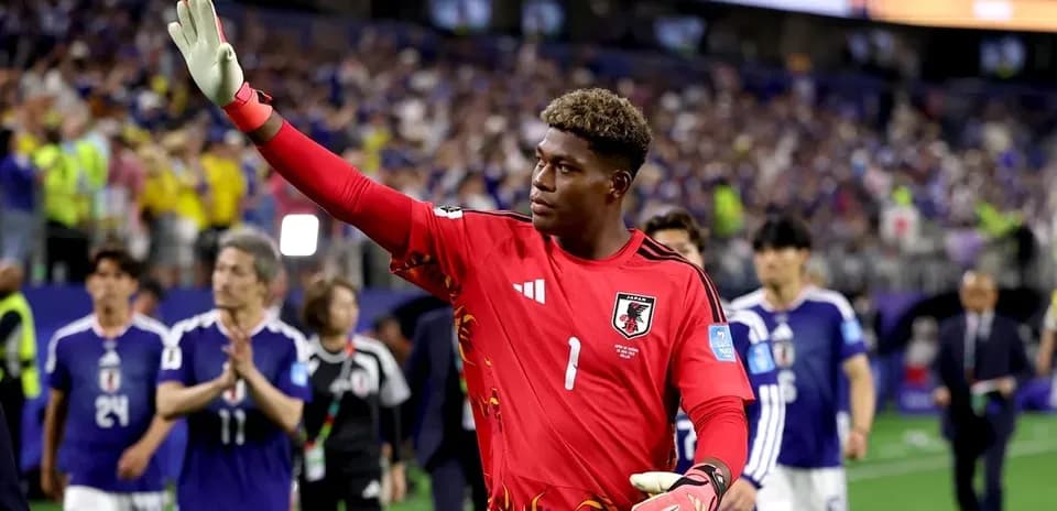 Goalkeeper in red jersey waving to fans