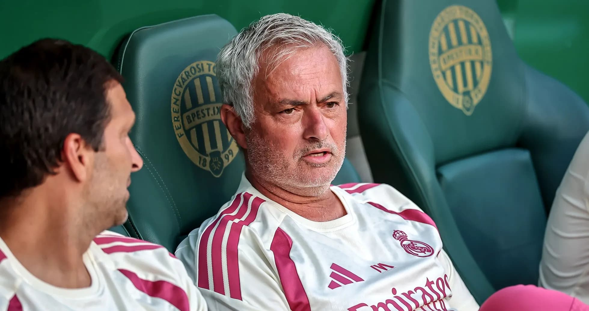 Men sitting on bench during a football match