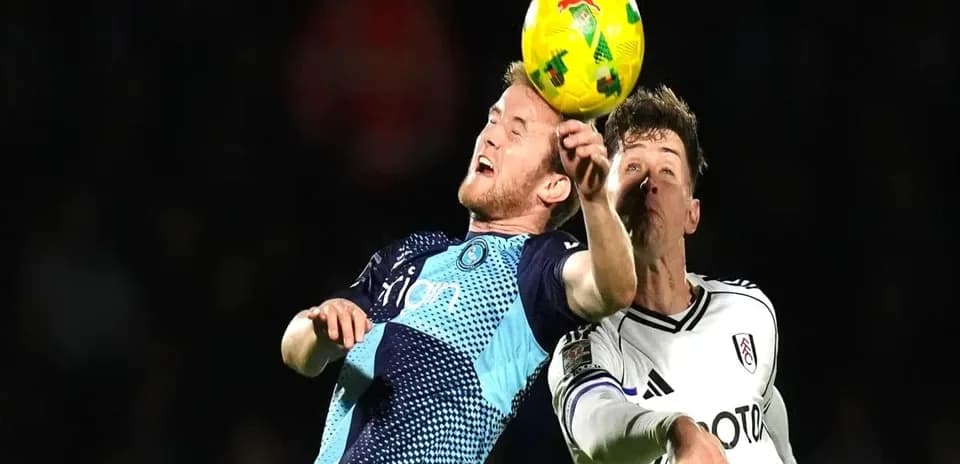 Players contesting a header during football match