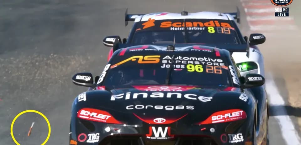 Two race cars competing on track with debris visible