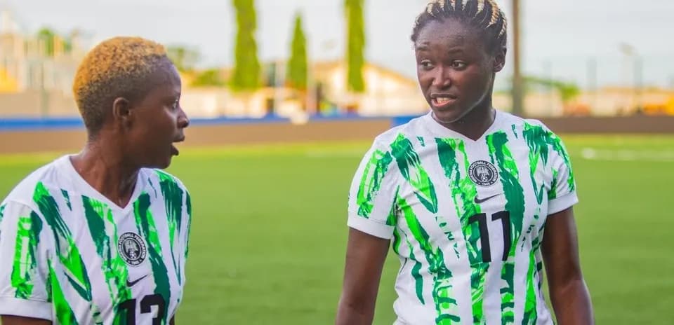 Ikki futbolchi maydonda muloqot qilmoqda