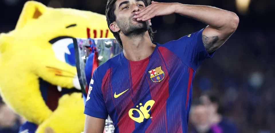 Futbolchi kubok bilan o'ralgan holda tabriklayapti