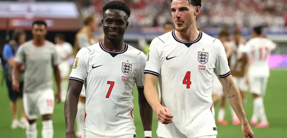 Two England players walking off the pitch after match