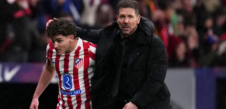 Atletiko Madrid coach assisting player off the field