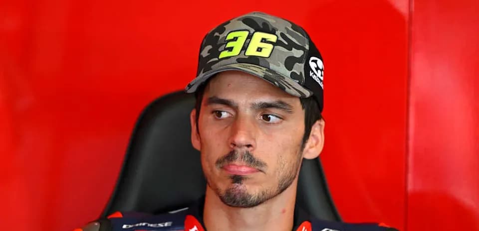 Motorsport athlete in team gear sitting in garage