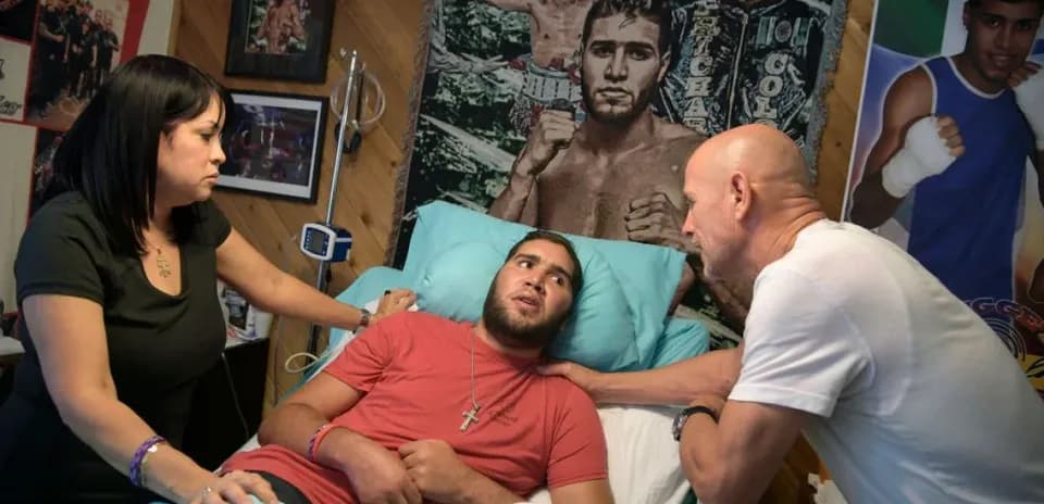 Man in bed with two people discussing health