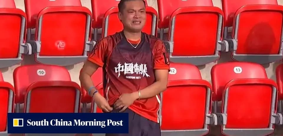Fan in orange shirt stands alone in empty stadium