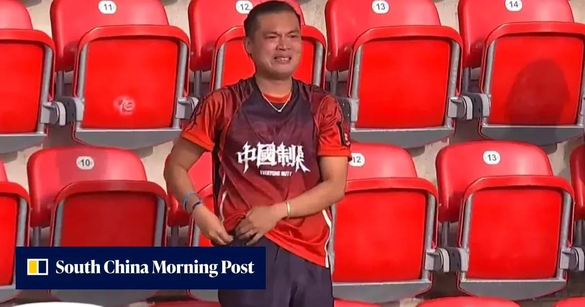 Fan in orange shirt stands alone in empty stadium