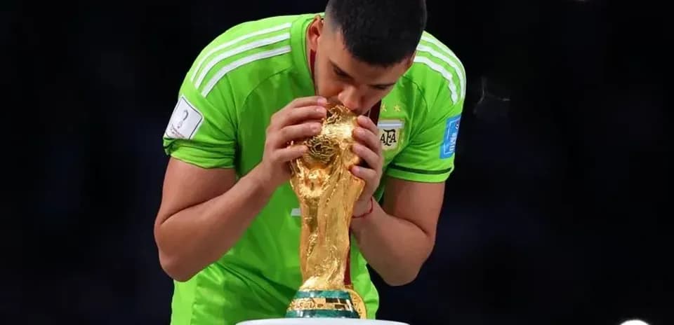 Goalkeeper kissing World Cup trophy on podium