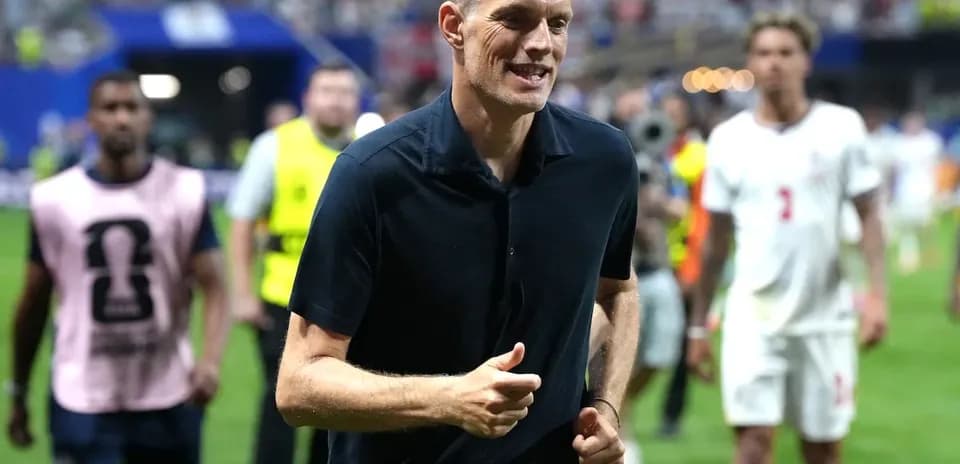 Coach walking on the pitch after the match