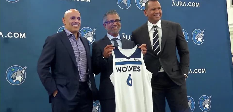Three men presenting a Minnesota Timberwolves jersey