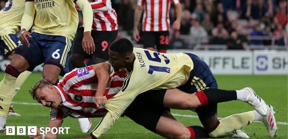 Two players competing for the ball on the ground
