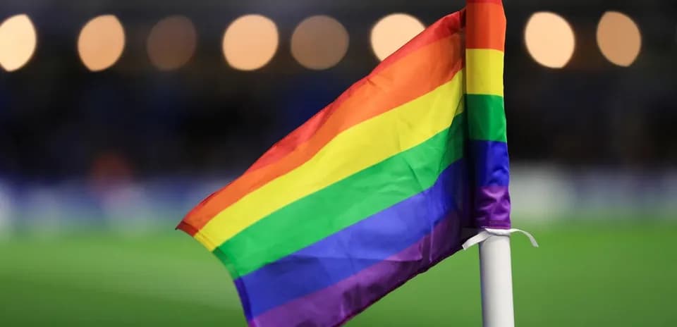 Rainbow flag on corner post at football match