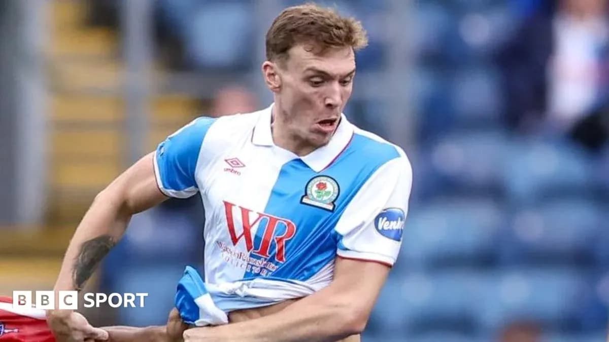 Futbolchi o'yin davomida formasi bilan shug'ullanmoqda