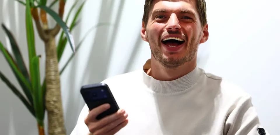 Young man laughing while holding a smartphone