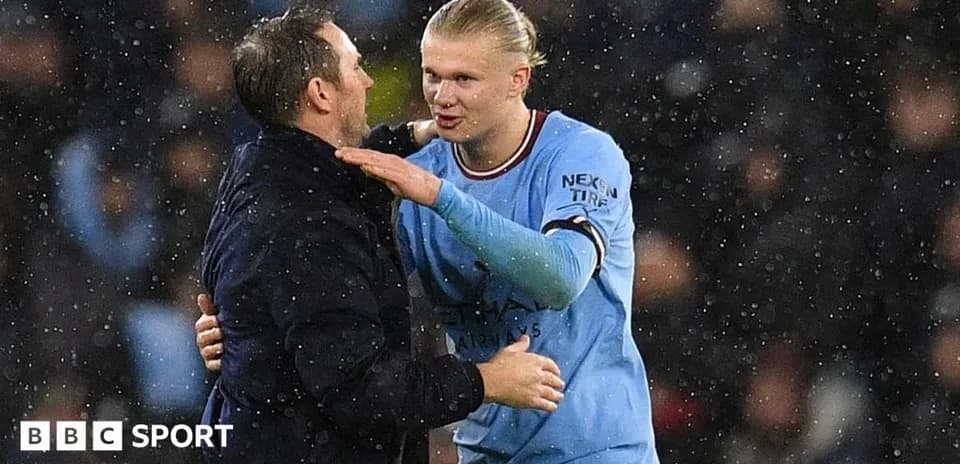 Haaland and manager embracing in rainy match