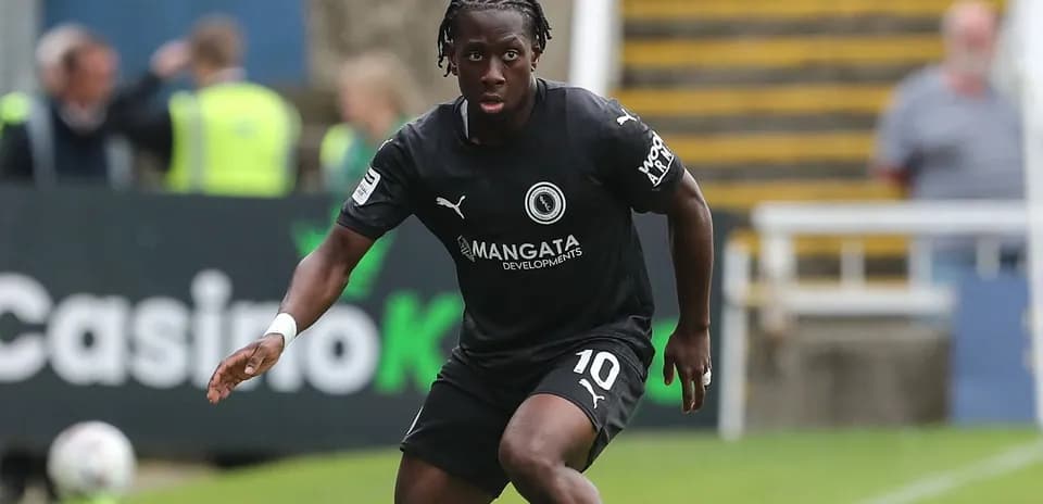 Futbolchi maydonda to'p bilan harakat qilmoqda