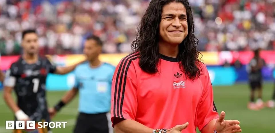 Futbolchi qizil forma kiyib, maydonda tabassum qilmoqda