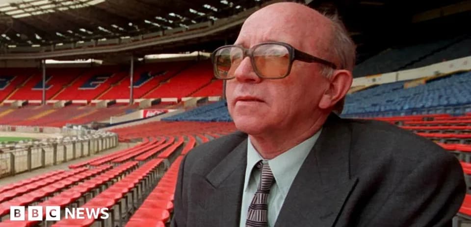Man sitting in empty stadium with red seats